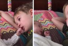 Un niño llora mientras le canta una canción de cuna a su hermanita menor